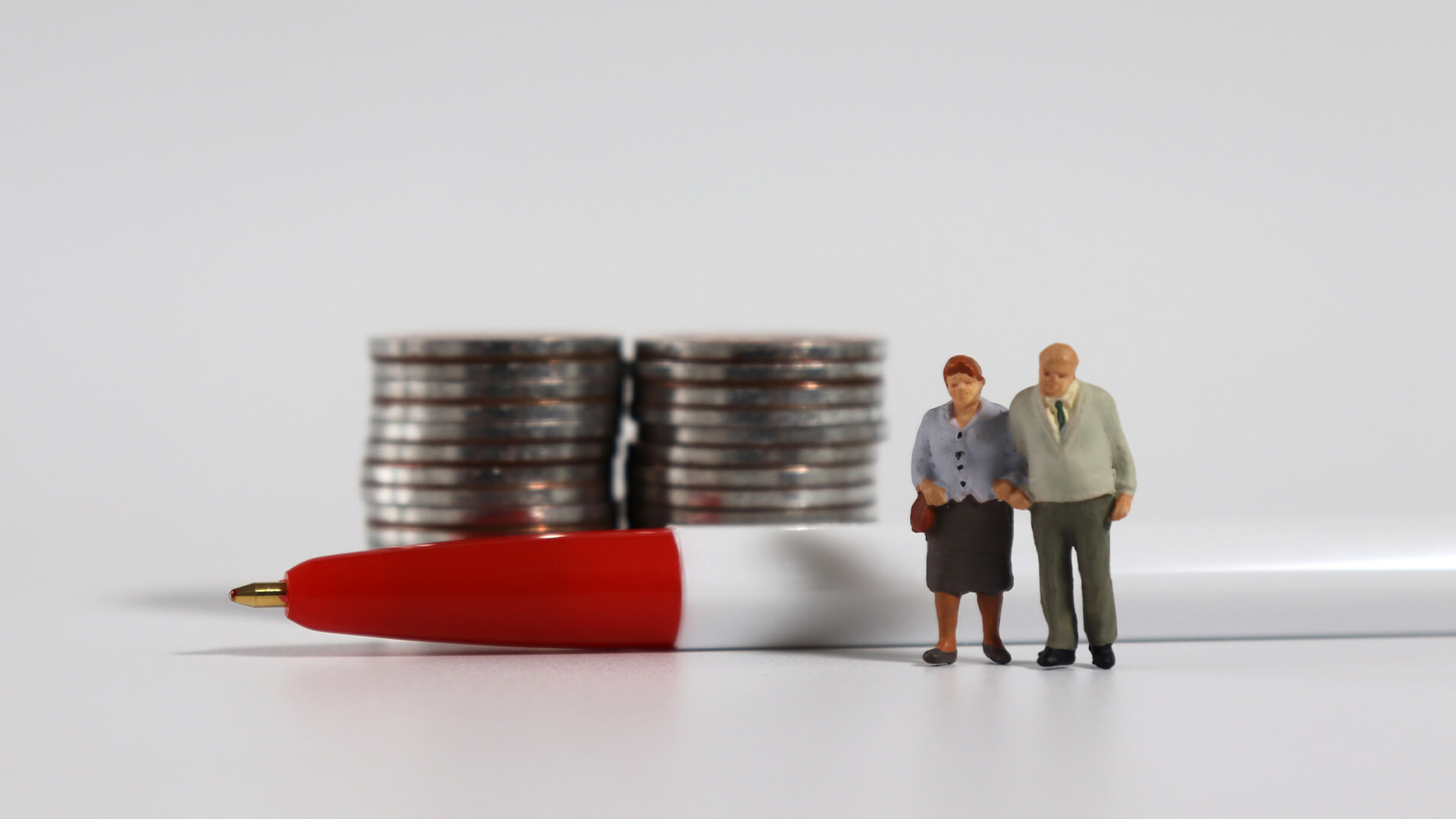 Plastic figures people standing in front of piles of coins