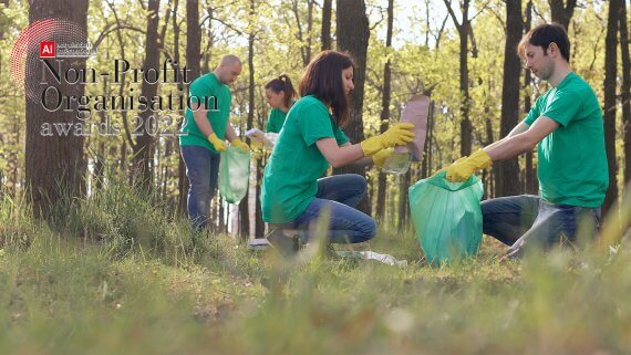 Group of volenteers cleaning up the enviroment in matching green t shirts. The Non-Profit Organisation Awards 2022 logo is in the top left corner