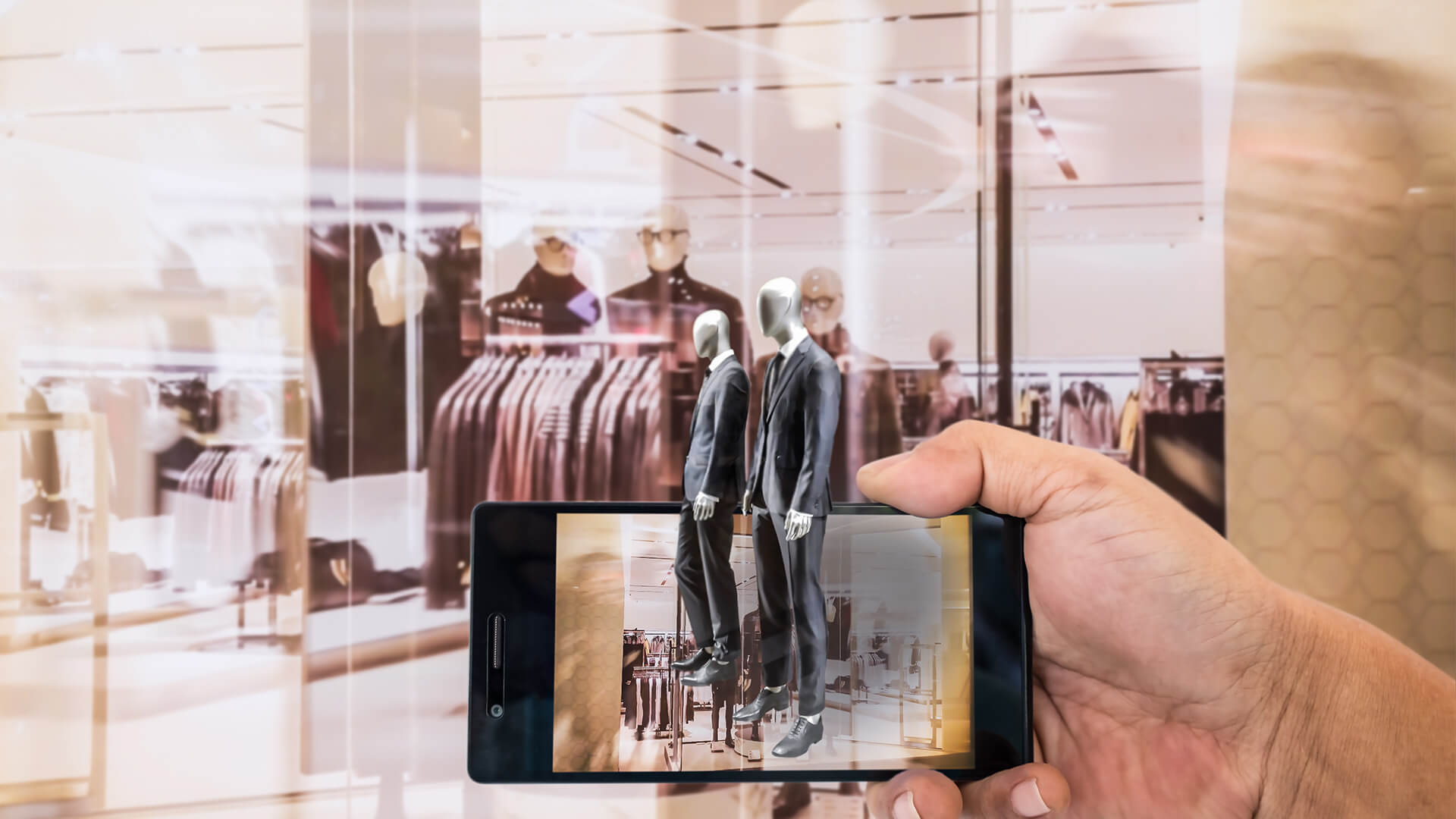 Smartphone being held with mannequins coming out of it and a clothes shop window in the background
