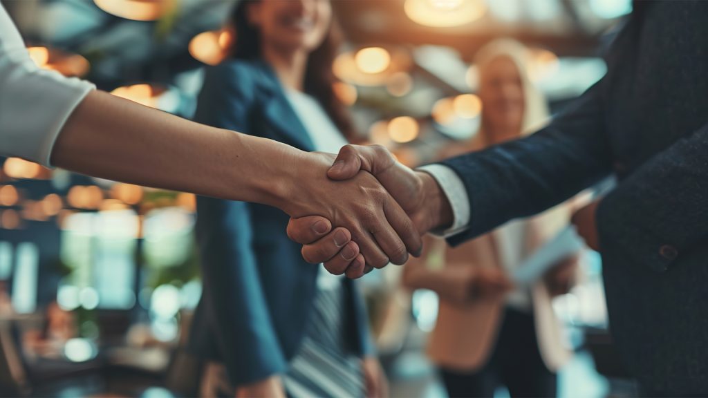 Business professionals engage in a close-up handshake