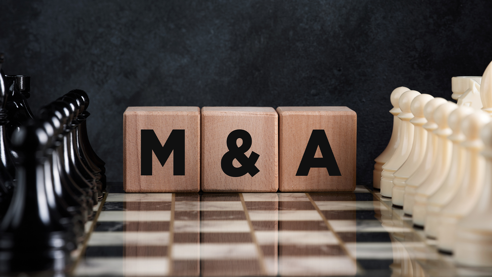 Chessboard with chess pieces and wooden blocks with the word mergers and acquisitions